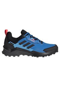 Chaussure de sport bleue et noire avec une tige texturée, dotée d'un bout renforcé, d'une semelle en caoutchouc et d'une boucle de talon rouge pour un enfilage facile.