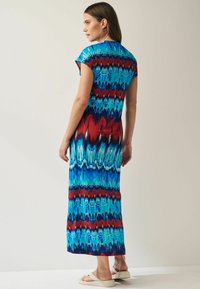 Maxi kjole i blå, rød og aqua tie-dye mønster. Korte ærmer, afslappet pasform og blødt stof med en flydende silhuet.