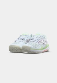 Scarpe da ginnastica bianche e verde chiaro con tomaia in maglia testurizzata, dettagli viola e suola in gomma con un motivo circolare.