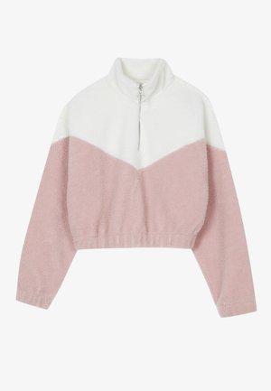 Fleece pūkinys su aukšta apykakle, turintis baltą viršutinę dalį ir rožinę apatinę dalį. Apima priekinį užtrauktuką ir raukšlėtą apatinę dalį.