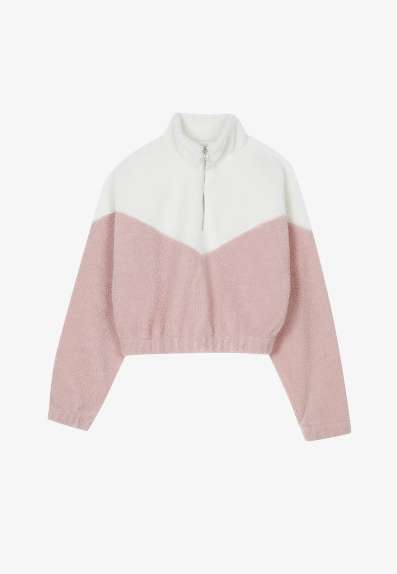 Pull en polaire avec un col montant, comprenant une partie supérieure blanche et une partie inférieure rose. Inclut une fermeture éclair à l'avant et un ourlet côtelé.