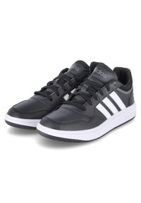 Scarpe da ginnastica nere con una tomaia sintetica liscia, caratterizzate da tre strisce bianche, lacci piatti e una suola intermedia bianca con una suola esterna nera texturizzata.