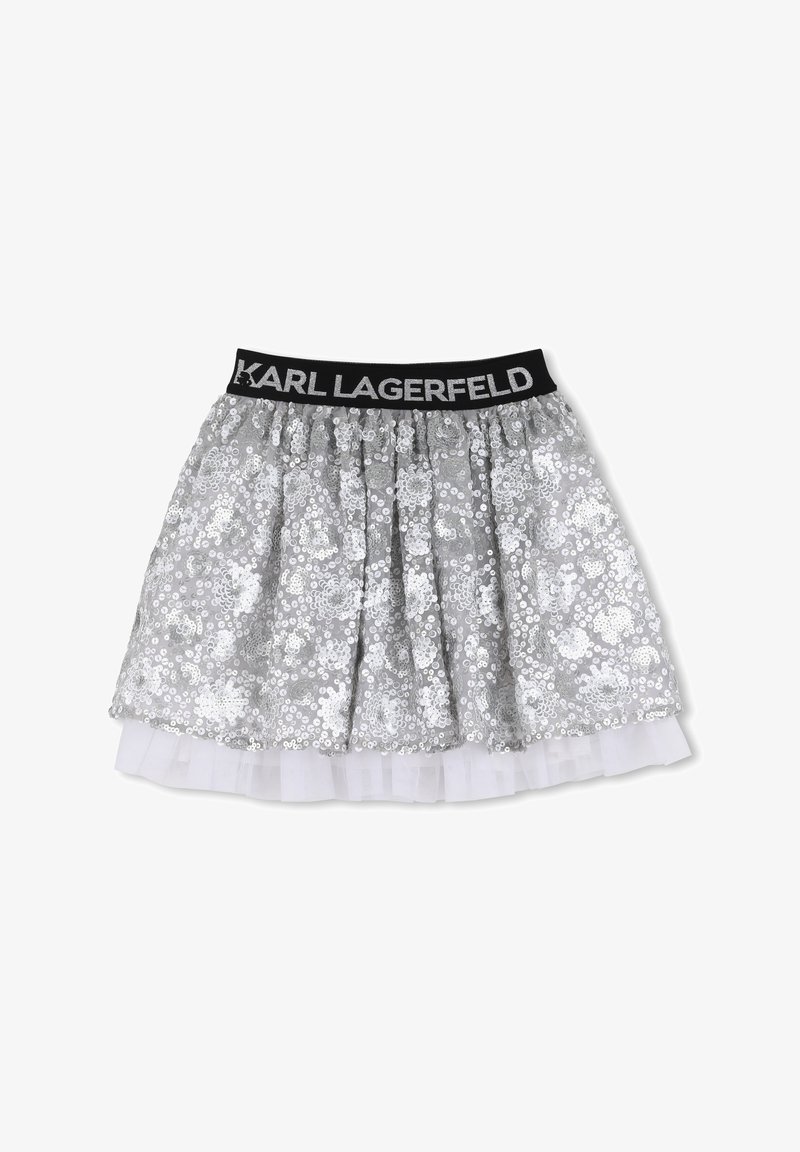 Jupe en sequins argentés avec une ceinture élastique noire ornée de "KARL LAGERFELD." Doublure en tulle superposée pour plus de volume. Coupe évasée.