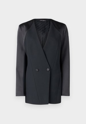 Mustmust valge jope, millel on struktureeritud siluett, satiinist õlavarre aktsendid ja tekstureeritud vooder. Sile kangas, millel on puhtad jooned.