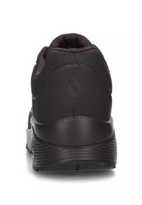 Scarpa sportiva nera con materiale testurizzato, collo imbottito e suola in gomma. Presenta piccole perforazioni e un design del tallone liscio.