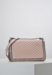 Borsa a spalla in pelle trapuntata rosa con un accento in catena argentata lungo i bordi e una singola tracolla, caratterizzata da un motivo a zigzag sul davanti.
