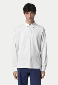Polo shirt bianco a maniche lunghe con colletto, patta con bottoni e piccolo logo sul petto. Tessuto morbido e fit rilassato.