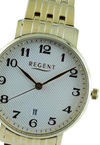 Montre dorée avec un cadran argenté texturé, index noirs, aiguilles dorées et affichage de la date à 6 heures. Bracelet en maillons métalliques.