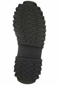 Suola di scarpa in gomma nera con scanalature e profili profondi per una buona aderenza. Design del tacco piatto e arrotondato.