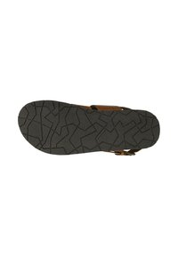 Sandale marron avec une semelle en caoutchouc noir texturé présentant un motif en zigzag, sangle réglable et design ouvert pour une bonne respirabilité.