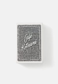 White box featuring a textured black grid pattern. "Café Kitsuné" is prominently displayed in white script, with "PARIS" below in smaller text.
