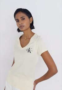 Calvin Klein Jeans MONOLOGO V NECK TEE - Triko s potiskem - vanilla
