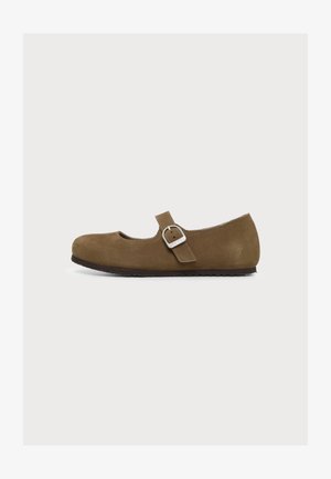 Chaussure Mary Jane en daim marron avec une bride à boucle argentée et une semelle noire, présentée de profil sur un fond clair.