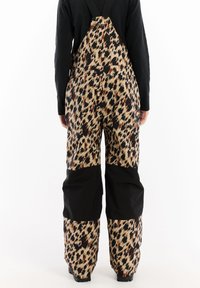 Dungarees con stampa leopardata e dettagli neri, con spalline regolabili e gambe ampie. Realizzati in tessuto resistente, presentano un motivo caratteristico e sezioni a contrasto.