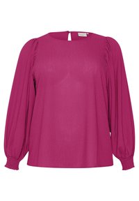 Blouse magenta à manches longues en tissu texturé, avec des poignets froncés et une petite ouverture au dos avec fermeture à bouton.