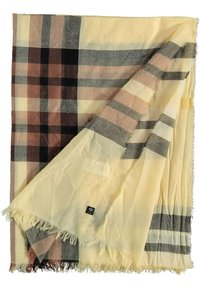 Bufanda a cuadros en tonos de beige, marrón y gris. Hecha de un material suave con bordes con flecos y una pequeña etiqueta de marca.