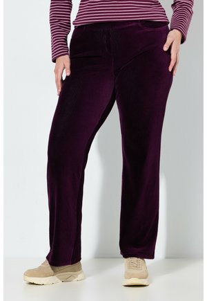 Purple corduroy pants with a straight-leg design, featuring side pockets and a textured finish, paired with beige sneakers.