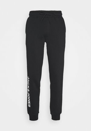 Sorte sweatpants lavet af blødt stof, med snoretræk i taljen og elastiske manchetter. Venstre ben har teksten "JACK & JONES" i hvid.