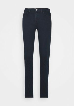 Jean slim bleu marine foncé avec cinq poches, fermeture par bouton et passants de ceinture, présenté à plat sur fond blanc.