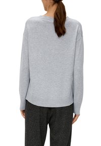 Hellgrauer Pullover mit lockerer Passform, gerippten Bündchen und Saum sowie einer glatten, weichen Textur. Rückansicht zeigt den runden Ausschnitt und minimale Details.