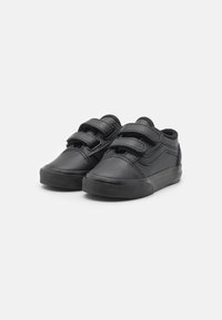 Chaussures en cuir noir avec deux fermetures à sangle, un profil bas, des semelles en caoutchouc texturé et des détails de couture le long des côtés.