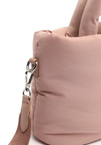 Vadderad rosa tote-väska med slät yta, utrustad med en silverfärgad metallklämma och ett mjukt bärhandtag i matchande nyans. Rundad form, minimalistisk design.