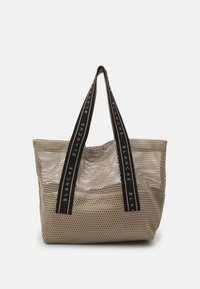 Offene Netz-Umhängetasche in hellbeige, mit schwarzen Trägern und dem Text "BLANCHE". Rechteckige Form mit geräumigem Innenraum und strukturierter Oberfläche.