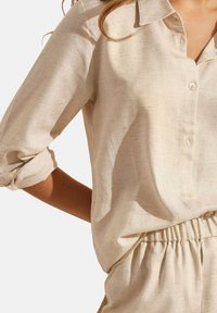 Overhemd met knopen in licht beige linnenmix met een kraag, opgerolde mouwen en subtiele textuur. Voorzien van knopen aan de voorkant en een relaxte pasvorm.