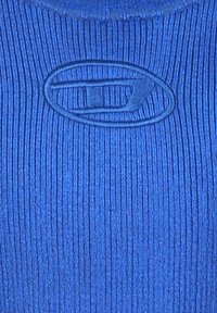 Tessuto blu a righe con un logo ovale in rilievo ben visibile al centro. La trama è liscia con linee verticali.