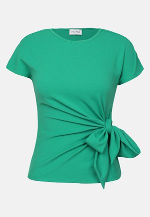 Green t-shirt made of soft fabric, featuring short sleeves and a front knot detail creating a twist effect on the left side.