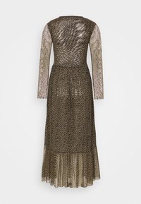 Robe midi à manches longues en tissu transparent à pois, taille cintrée et ourlet volanté. La couleur est foncée avec des pois plus clairs.