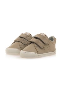 Scarpe in pelle beige con due fibbie in velcro, suola in gomma e design perforato sui lati. Presentano un bordo cucito bianco.