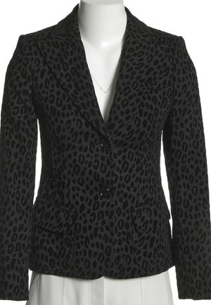 Blazer noir cintré avec motif léopard foncé, deux boutons, col à revers crantés et poches à rabat sur un torse de mannequin blanc.