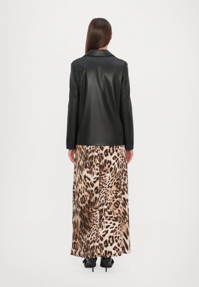 Black faux leather blazer paired with a long, leopard print skirt. Smooth texture, tailored design, and high-heeled shoes are visible.
