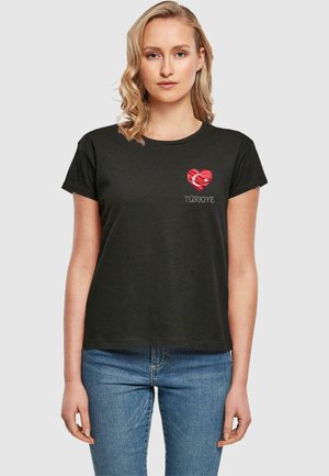 T-shirt en coton noir à manches courtes, avec un motif de cœur rouge orné du drapeau turc et du mot "TÜRKİYE" en texte gris.
