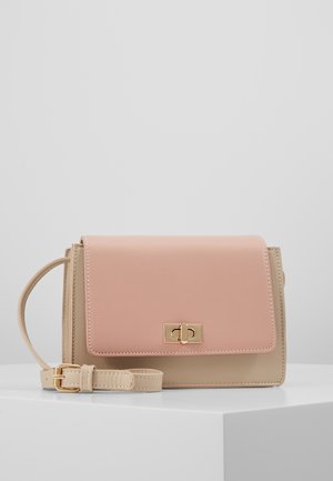 Sac bandoulière rectangulaire en cuir beige et rose avec fermoir doré à tourniquet et sangle réglable sur surface blanche.