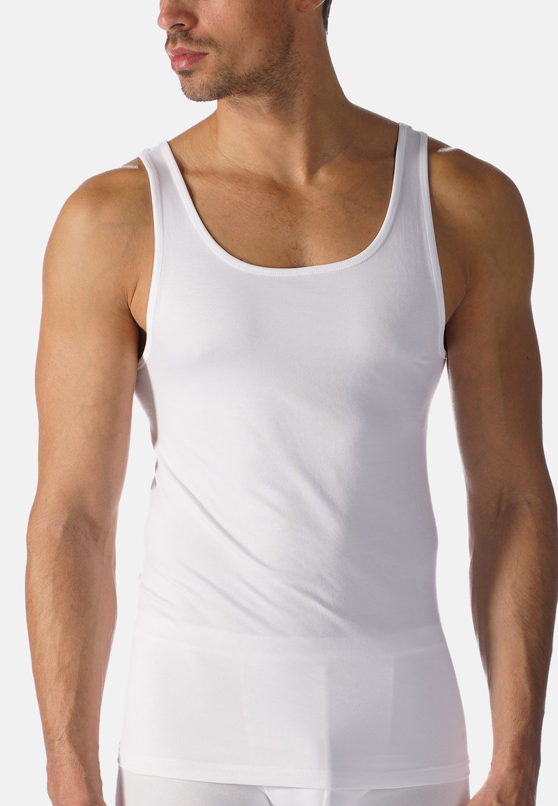 White, sleeveless tank top made of soft cotton fabric with a round neckline and fitted design, featuring minimal seams and smooth texture.