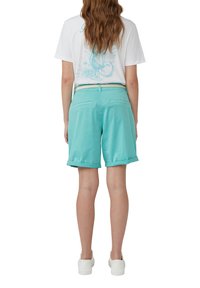 Turquoise katoenen bermuda shorts met opgerolde zomen, met twee achterzakken. Gecombineerd met een wit T-shirt met een lichtblauw grafisch ontwerp.