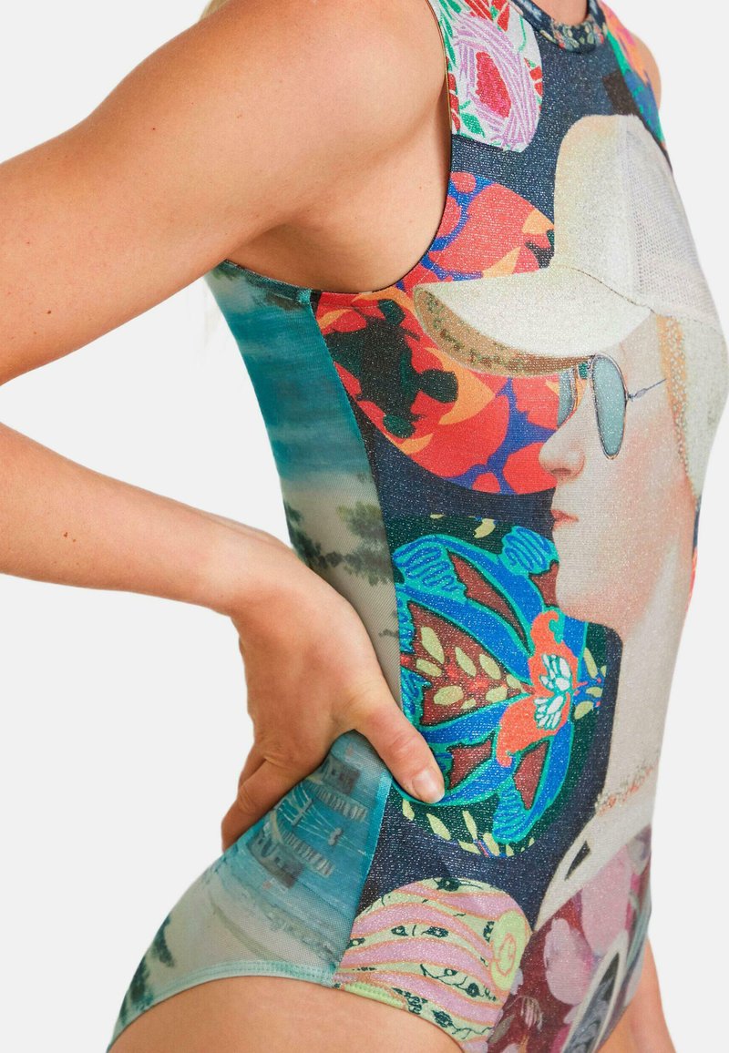 Bañador de una pieza con un diseño gráfico colorido que presenta varios patrones y texturas; ajustado, con cuello alto y aberturas para los brazos.