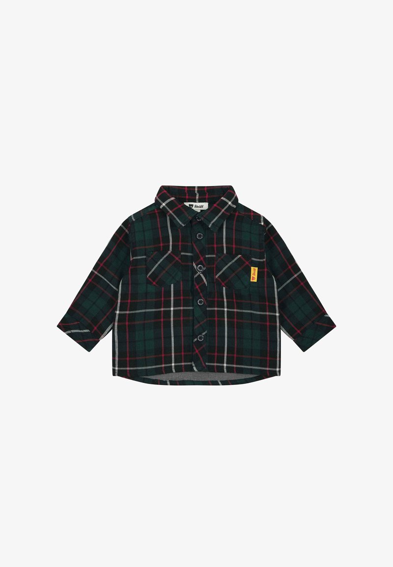 Chemise à carreaux verte, noire, rouge et blanche à manches longues, avec deux poches avant et une petite étiquette jaune sur la poche gauche.