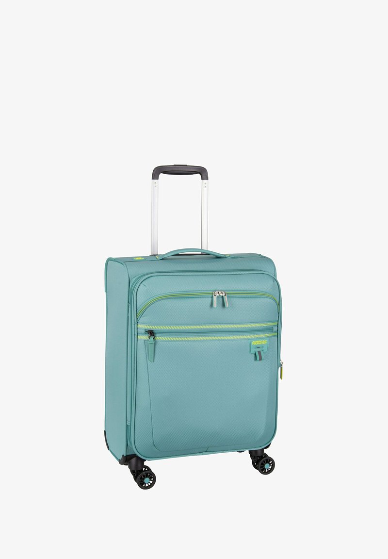 Light teal polycarbonate suitcase with two front pockets, topped with a retractable handle and four wheels for easy maneuverability.