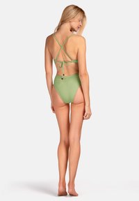 Zielony dwuczęściowy strój kąpielowy z krzyżującym się tyłem, wiązanymi ramiączkami, wysokimi majtkami oraz ozdobnymi guzikami z tyłu.