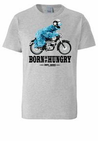 Camiseta de algodón gris con un personaje peludo azul montando una motocicleta y el texto "NACIDO PARA TENER HAMBRE" y "EST. 1966" en negro.