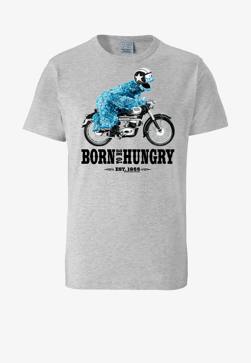 Camiseta de algodón gris con un personaje peludo azul montando una motocicleta y el texto "NACIDO PARA TENER HAMBRE" y "EST. 1966" en negro.