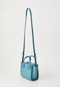 Small teal leather handbag featuring dual handles, an adjustable long strap, and textured material with contrasting black accents.