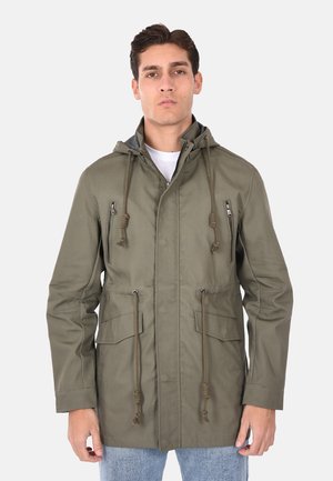 Giacca con cappuccio verde oliva, dotata di zip e dettagli delle tasche, cordini regolabili e un tessuto leggero e testurizzato.