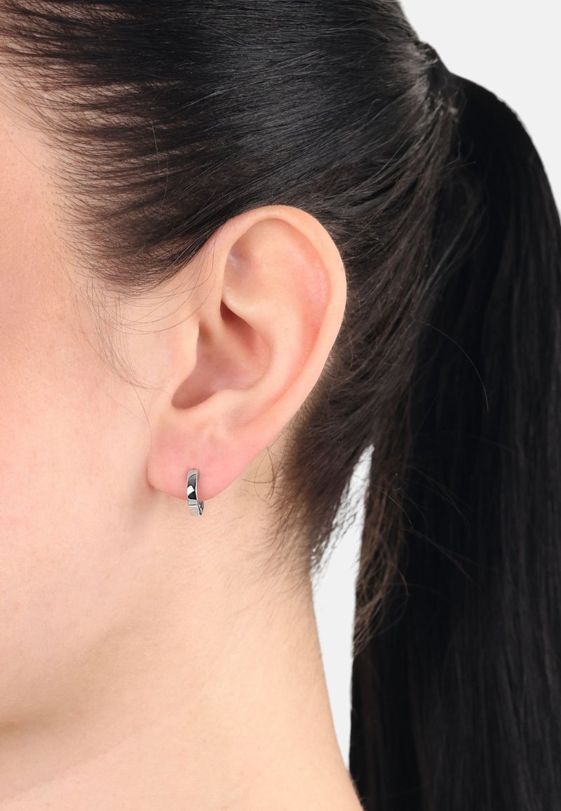 Pendiente de aro de plata con un acabado pulido, que presenta un diseño circular y suave que abraza de cerca el lóbulo de la oreja. Minimalista y elegante.