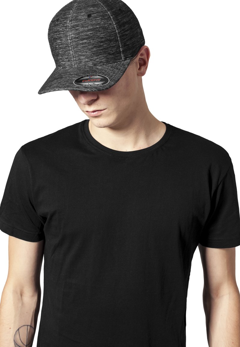 Sort fitted cap med et tekstureret grå kulmønster, buet skygge og et logo foran. Båret med en simpel sort T-shirt.
