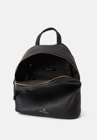 Zaino in pelle nera con zipper oro, parte superiore arrotondata e tasca interna. Presenta un'etichetta del marchio, una texture liscia e una forma strutturata.