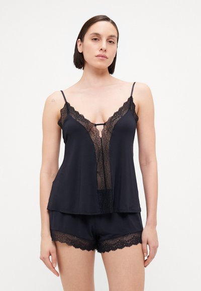 Black lace cami top with thin straps, deep V-neck, and layered design; paired with matching shorts featuring lace hem. Soft fabric texture.